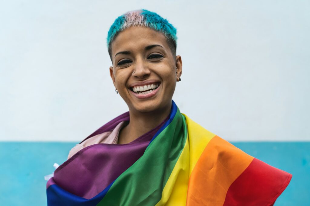 a woman with blue hair and rainbow flag