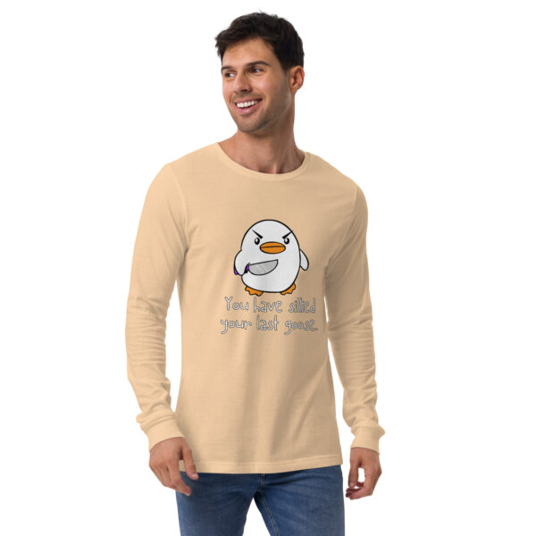 A man wearing a beige long-sleeve shirt featuring a cartoon penguin with the text "You Have Sillied Your Last Goose.