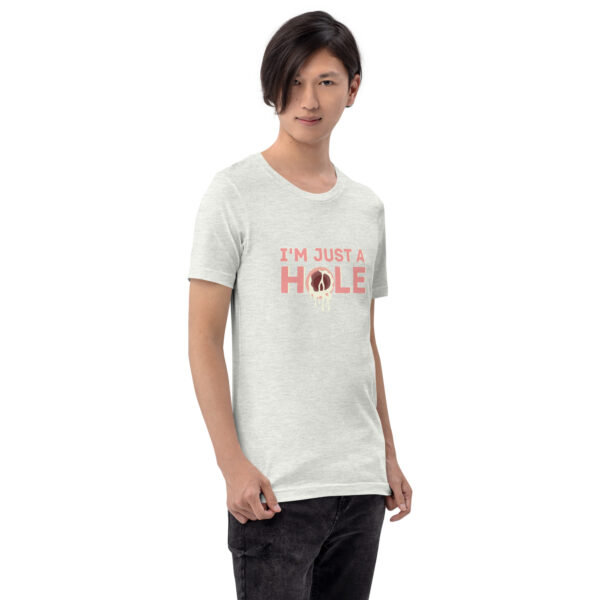 A person with medium-length hair is wearing a light gray "I'm Just a Hole" t-shirt that features pink lettering and a central design.