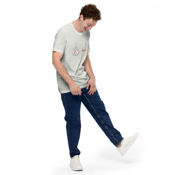 A person wearing a gray "Really?! I washed my balls for this!" t-shirt and blue jeans stands on one leg, looking down, set against a white background.