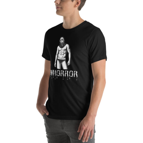 A person wearing a Whorror black T-shirt with an illustration of a muscular figure with a mask, positioned above dripping text.