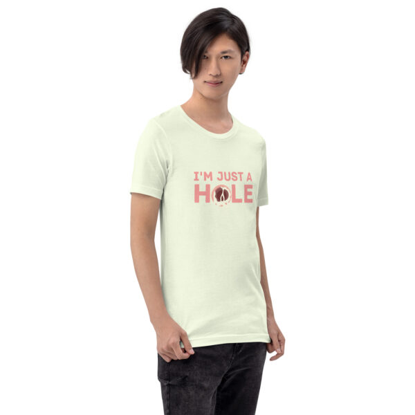 A person wearing the "I'm Just a Hole" light green T-shirt, featuring a donut graphic, is standing against a plain white background.