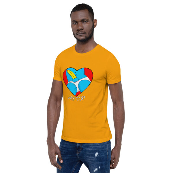 A man wearing "His Top," a yellow t-shirt that showcases a graphic of a blue and red heart with a cartoon bird, stands against a plain white background.