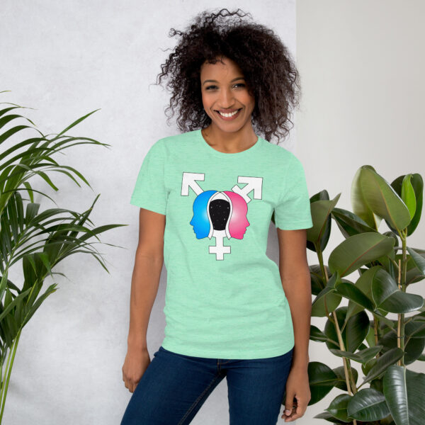 A smiling person wearing the "Beyond the Binary" T-shirt, featuring a gender symbol graphic, stands next to green plants.