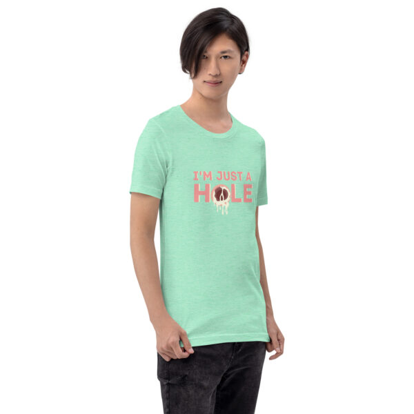 A person wearing the 'I'm Just a Hole' mint green T-shirt, featuring a graphic of a donut and bold text, stands against a plain white background.