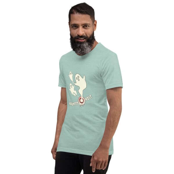 A person is wearing a light green T-shirt featuring a ghost graphic and the text "Haunted Hole.