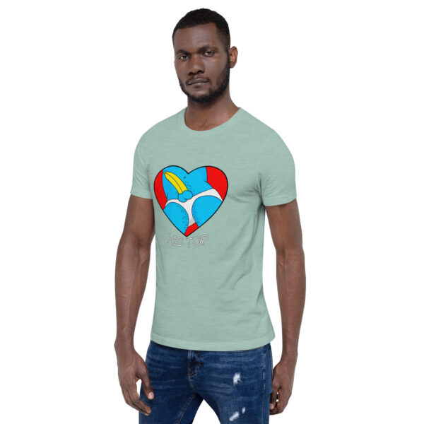 A man wearing "His Top," a light green t-shirt featuring a vibrant cartoon heart design, paired with distressed jeans.