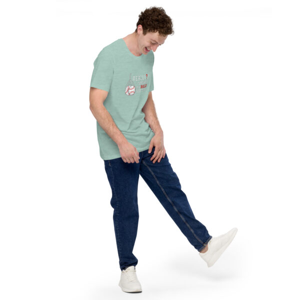 A person stands looking down with one leg slightly raised, wearing a light green "Really?! I washed my balls for this!" t-shirt, blue jeans, and white sneakers against a plain white background.