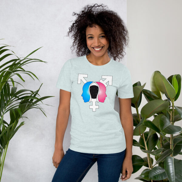 A person wearing the "Beyond the Binary" t-shirt, featuring a gender identity symbol, stands next to indoor plants and smiles at the camera.