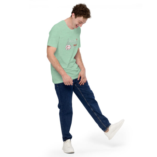 A man in a green T-shirt and blue jeans is balancing on one leg, smiling and looking down, while wearing the "Really?! I washed my balls for this!" white sneakers.