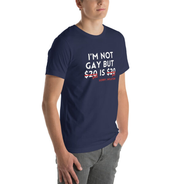 A person wearing the "I'm Not Gay" navy blue t-shirt featuring the text, "I'm not gay but $20 is $20," and the phrase "sorry, inflation" crossed out in red beneath it.