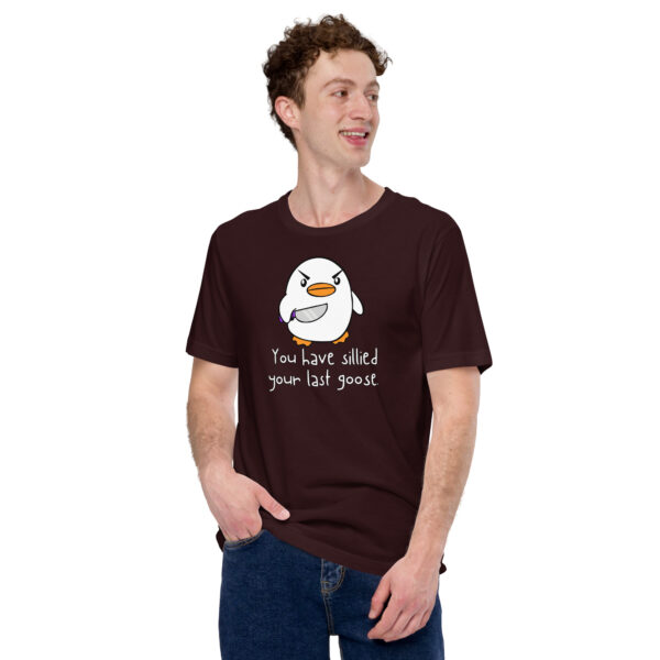 A person smiling and looking to the side while wearing a dark t-shirt featuring a cartoon goose and the phrase from the "You Have Sillied Your Last Goose" product line.