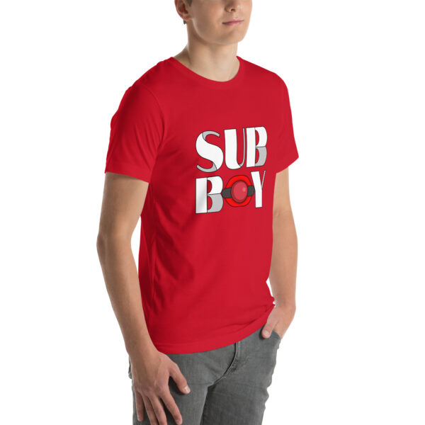 A person wearing a red t-shirt labeled "Sub Boy" stands casually with hands in their pockets.