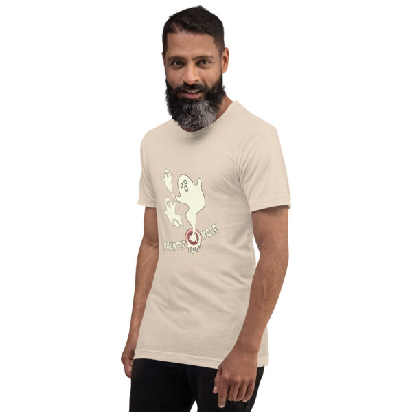 Man wearing a beige t-shirt featuring a cartoon ghost and the words "Haunted Hole" printed on it.