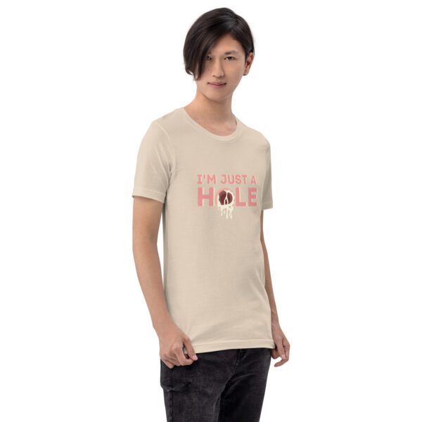 A person wearing the "I'm Just a Hole" beige T-shirt featuring a graphic of a donut.