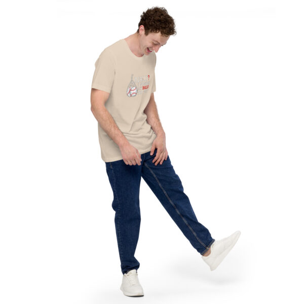 The individual wearing a light-colored t-shirt with the slogan, "Really?! I washed my balls for this!" and jeans stands on one leg, smiling with one hand resting on the raised knee.