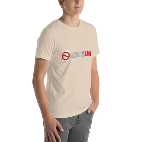 A person wearing a Unisex t-shirt in beige featuring the text "RAW IS LAW" and a no entry sign graphic over a bottle.