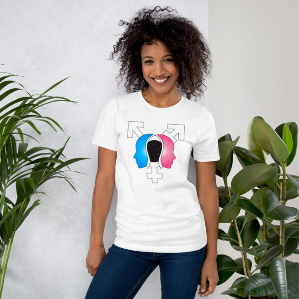 A smiling person wearing the "Beyond the Binary" white shirt, standing beside green plants.