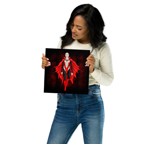 A person in a white long-sleeve shirt and jeans holds a square print featuring Count Matthew Clyde, a character in a red and black costume with a cape.