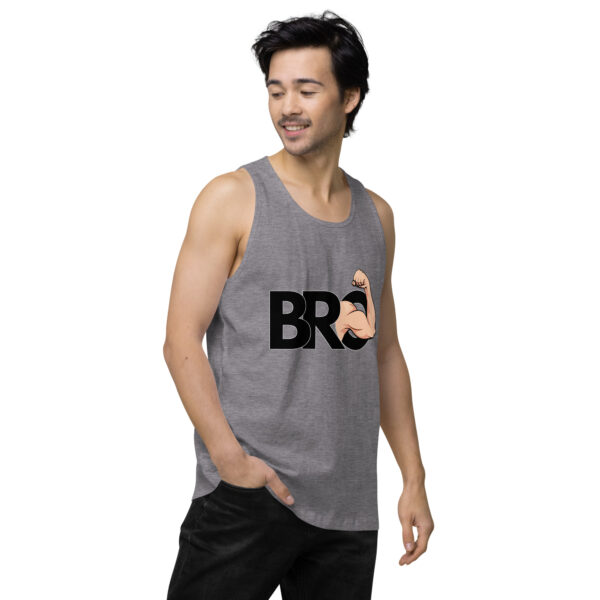 A person wearing the Bro Tank, featuring a "BRO" design with an arm flexing graphic, looking to the side with one hand in their pocket.