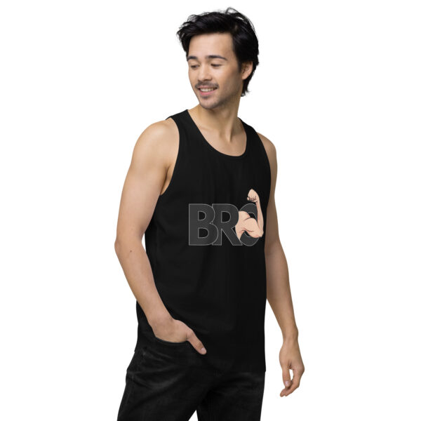 A person wearing the "Bro Tank," which is a black tank top with "BRO" and a flexed arm graphic, stands with one hand in their pocket, looking to the side.