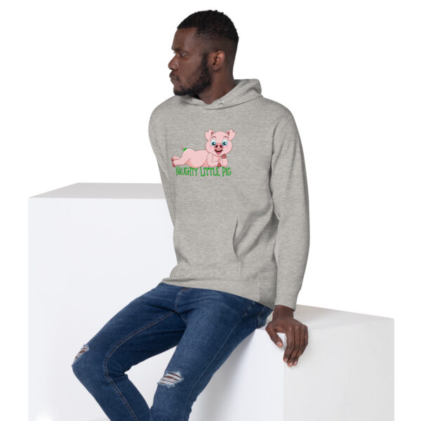 A man is sitting on a white block wearing the Naughty Little Pig Hoodie, which features a cartoon pig design.