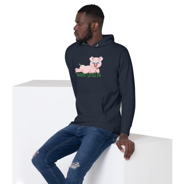 A man wearing the **Naughty Little Pig Hoodie**, featuring a cartoon pig design, sits on a white block, looking to the side.