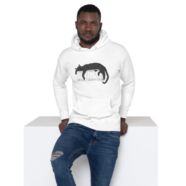 Man wearing a BIDC Hoodie featuring a black cat design and text, leaning against a white surface.