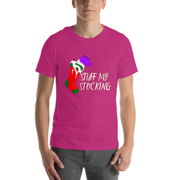 A person is wearing a vibrant pink shirt featuring the "Stuff My Stocking" graphic, which displays a Christmas stocking design along with the text.