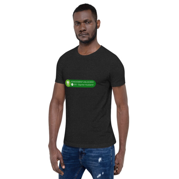 Man wearing a black "Achievement: Gaymer Husband" t-shirt, standing with a neutral expression.