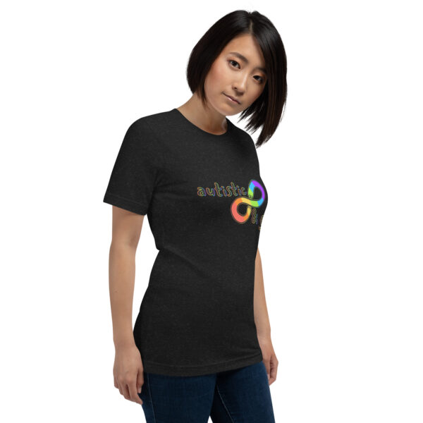 A person wearing the "Autistic & Gay" T-shirt, which features a colorful infinity symbol and the word "autistic," stands against a white background.