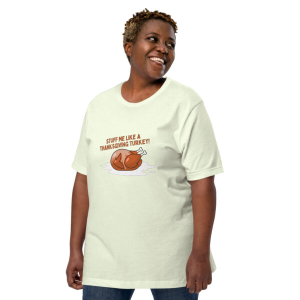 A person sporting the "Stuff Me" T-shirt, which features a cartoon turkey and the phrase "STUFF ME LIKE A THANKSGIVING TURKEY!", smiles and looks to the side.