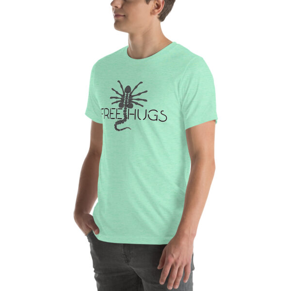 A person wearing a light green "Free Hugs" t-shirt featuring a scorpion graphic.