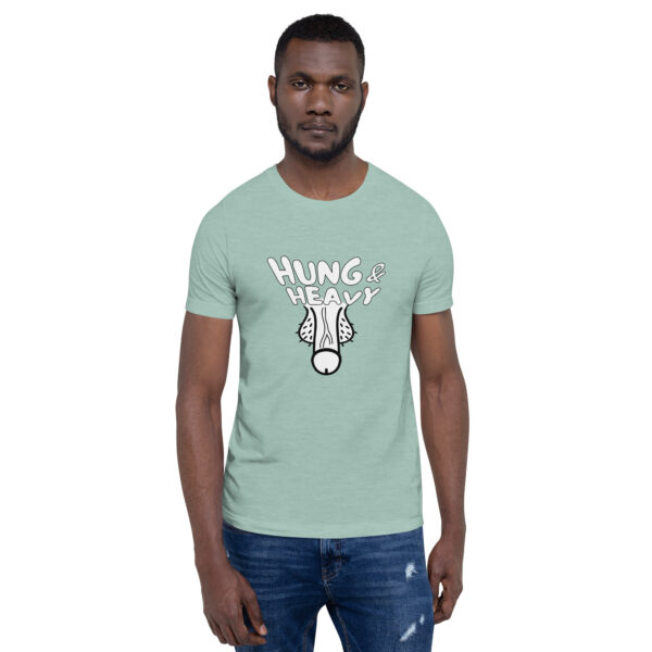 A man wearing a mint green Hung and Heavy T-shirt featuring a cartoon illustration, standing against a white background.