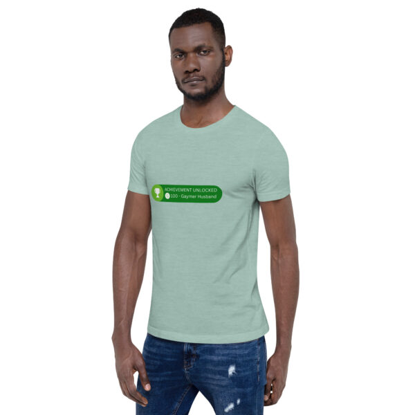 Man wearing a green T-shirt with the text "Achievement Unlocked: 100 - Gaymer Husband" from the Achievement: Gaymer Husband collection across the chest.