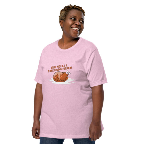 A person wearing the "Stuff Me" pink T-shirt featuring a cartoon turkey and the humorous text "STUFF ME LIKE A THANKSGIVING TURKEY!