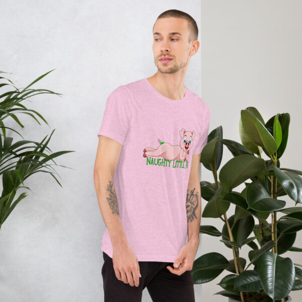 A man wearing a pink "Naughty Little Pig" t-shirt featuring a cartoon pig design stands beside some green plants.