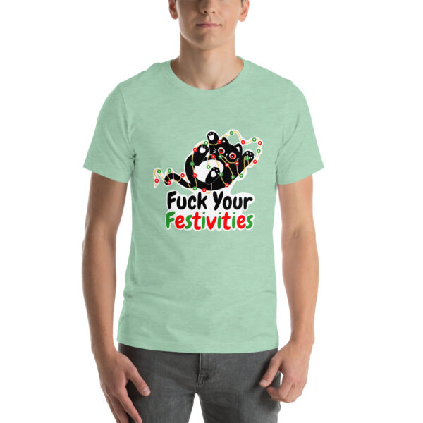 A person wearing the "Fuck Your Festivities" t-shirt in mint green, featuring colorful text and a playful design.