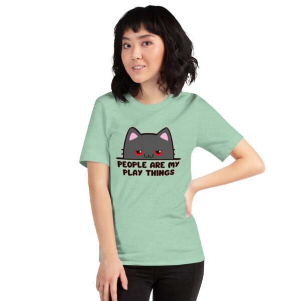 A person wearing a green T-shirt featuring a cartoon cat and the product name "People Are My Play Things.