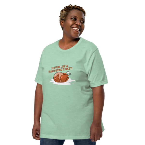 A person is wearing the "Stuff Me" light green t-shirt featuring a turkey graphic and the text "Stuff Me Like A Thanksgiving Turkey!".