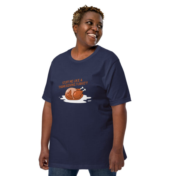 A person wearing the "Stuff Me" navy T-shirt featuring a cartoon turkey design and the text "STUFF ME LIKE A THANKSGIVING TURKEY!