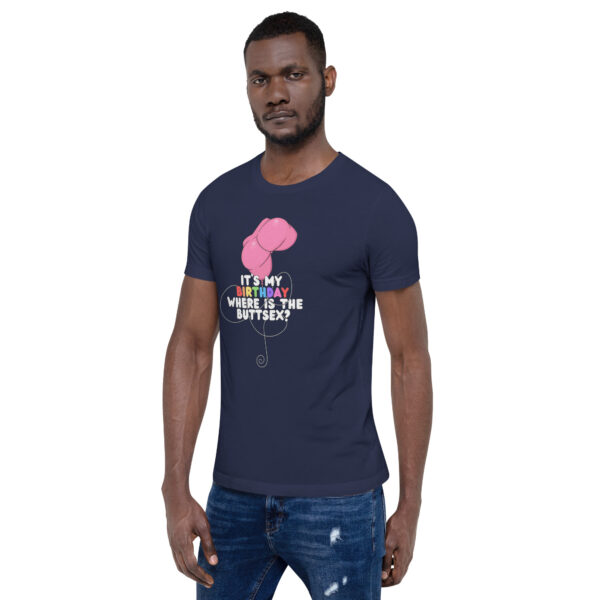 Man in a navy "It's My Birthday" t-shirt featuring a pink balloon graphic and text, standing against a plain background.