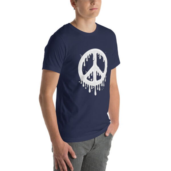 A person wearing the "Cum in Peace" navy T-shirt featuring a white, dripping peace symbol stands with their hands in their pockets.