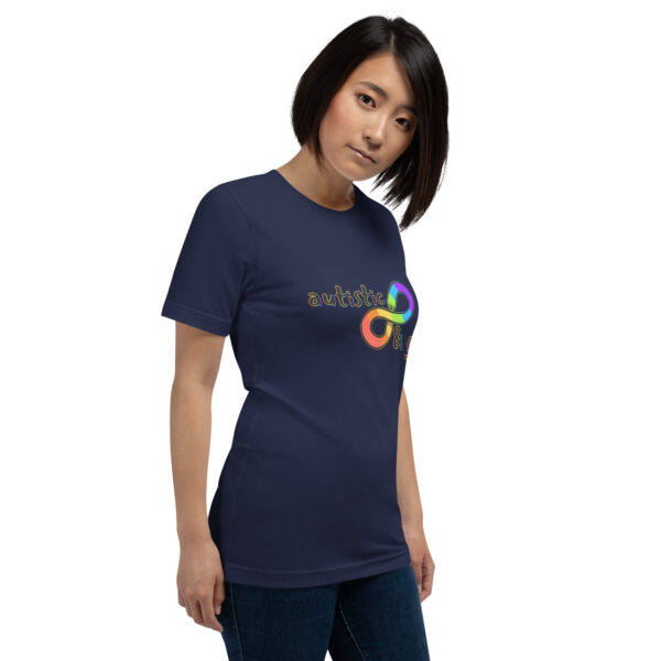 A person wearing a navy T-shirt featuring a colorful infinity symbol and the phrase "Autistic & Gay.