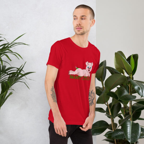 A man with short hair wearing a red t-shirt featuring the "Naughty Little Pig" design stands near potted plants.