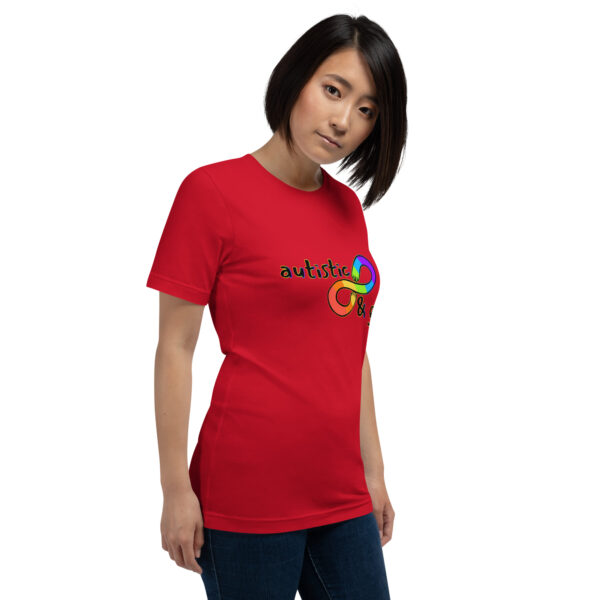 Person wearing a red T-shirt featuring the product "Autistic & Gay," which has a colorful infinity symbol and the word "autistic" on the front, standing against a white background.