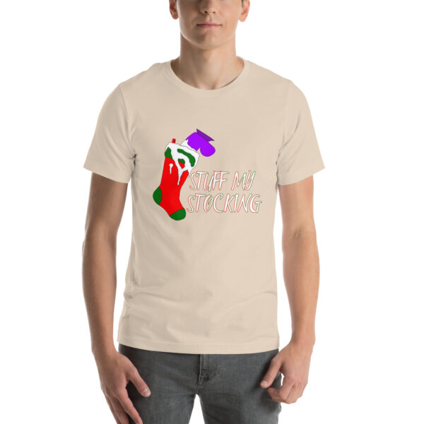 A person dressed in a "Stuff My Stocking" beige t-shirt, showcasing a colorful Christmas stocking design along with the text.