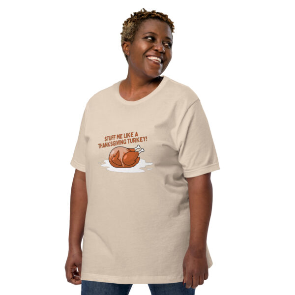 Individual sporting a beige "Stuff Me" T-shirt, featuring a cartoon turkey and the playful phrase "Stuff me like a Thanksgiving turkey!