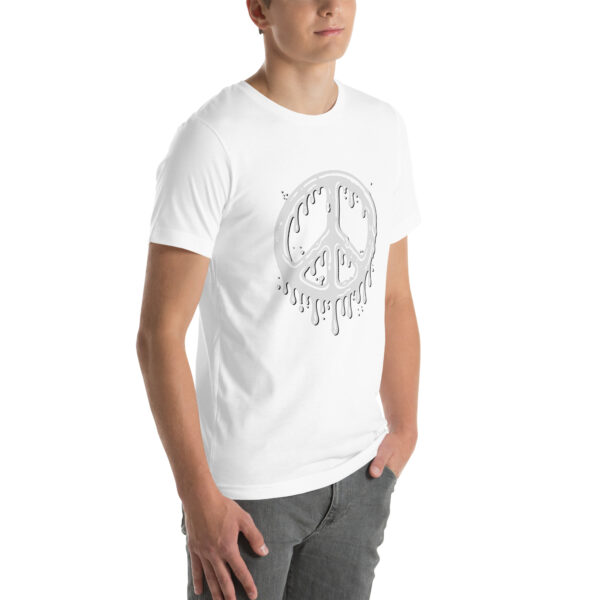 A person wearing the "Cum in Peace" white t-shirt featuring a dripping peace symbol design, with their hands in their pockets.