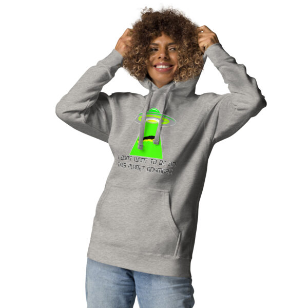 A person wearing the "I don't want to be on this planet anymore" hoodie, featuring a gray color with a green alien spaceship design and text.